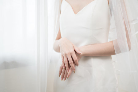 Beautiful asian bride with fashion wedding hairstyle and makeup. Portrait of young gorgeous bride wedding studio shot in white room.の写真素材