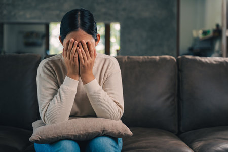 Depressed and Stressed asian woman on sofa. Crying sadness female alone in home problem in life. Unhappy asian woman headache Upset frustrated by problem love relationship feeling despair and anxietyの写真素材