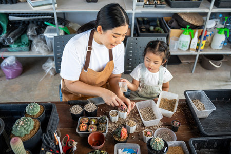 Happy family mother and her daughter concept, asian young mom and baby girl spending time together with planting, parent and her child doing hobby, the quality time for children activities at home.の写真素材