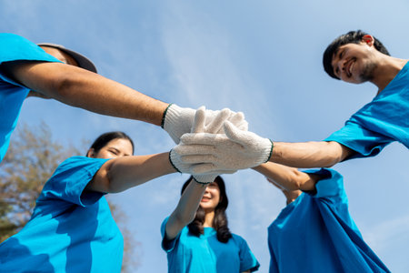 Group teamwork volunteer put their hands together. People male and female Volunteer with garbage bags clean the trash on the beach make the sea beautiful. World environment day CSR.の写真素材