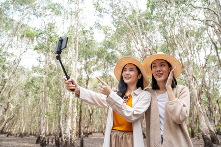 Happy asian friends traveling in the forest. Happy weekend on vacation time. Attractive Lesbian couple female traveler walking in nature spend time enjoy with holidayの写真素材
