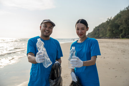 Group teamwork volunteer pick up the plastic bottle on the beach. People male and female Volunteer with garbage bags clean the trash on the beach make the sea beautiful. World environment day CSR.の写真素材