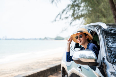 A young beautiful asian woman travel to the sea by car on a bright day. With beautiful blue sky....