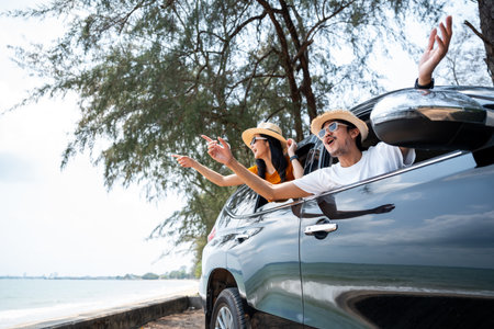 Young asian couple man and woman travel by car on a bright day to the sea sand beach with beautiful...