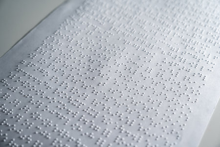 Close up some braille text on page paper written by blind. Blind man using slate and stylus tools making embossed printing the braille alphabet Code on sheet.の写真素材