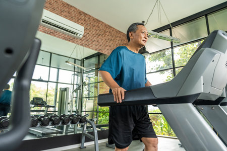 Senior old man runner exercise indoor gym. fitness man jogging wearing sportswear. Mature athlete...