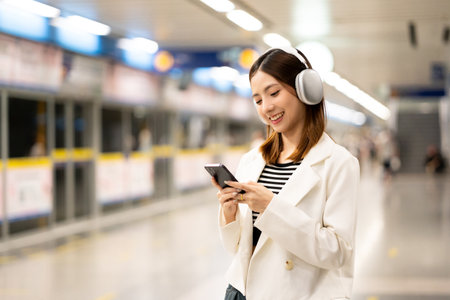 Young asian woman using smartphone application navigate location destination while travel by subway....