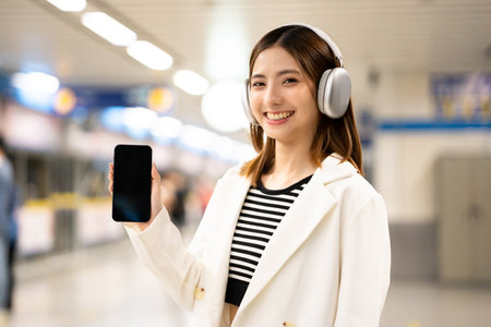 Young asian woman using smartphone application navigate location destination while travel by subway....