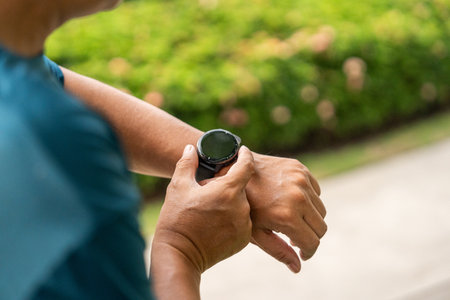 Mature man wearing sportswear using Smart Watch Showing Heart Rate Monitor. Old man with Technology for health and sport mode. Exercise and take statistics to develop your potentialの写真素材