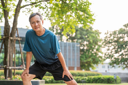 Senior old asian man wearing sportswear warming up before running outdoor. Portraits of Mature man...