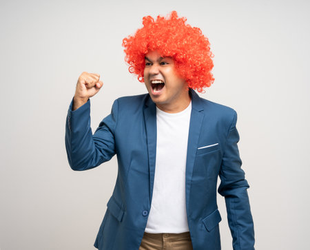 Shocked face Young Asian man with afro Hairstyle pointing finger to blank space for advertise. Funny smiling happiness man with suit jacket on isolated white background.の写真素材