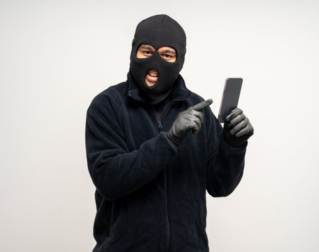 Thief in uniform black jacket various pose on isolated background. The Robber terrorism criminal escapes with balaclava and crowbar entering a house for stealing Housebreakの写真素材