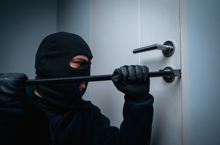 Thief in uniform black jacket various action housebreak. The Robber terrorism criminal escapes with balaclava and crowbar entering a house for stealing Housebreak at nightの写真素材