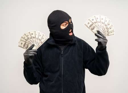 Thief in uniform black jacket various pose on isolated background. The Robber terrorism criminal escapes with balaclava and crowbar entering a house for stealing Housebreakの写真素材