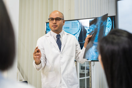 Medical team doctor planning research in a hospital and talking about patient symptoms as results x ray film. Discussion healthcare meeting group speaking about medicine strategy various actionの写真素材