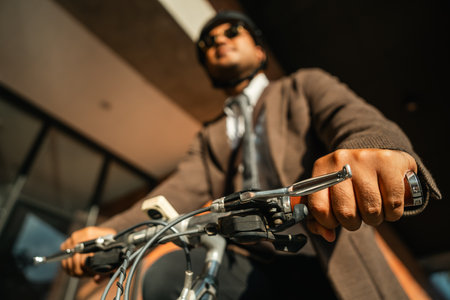 Asian businessman riding bike in city. sustainable save energy lifestyle. Commute and carbon neutral transportation. Asian man put on helmet cycling bike to working office in urban cityの写真素材