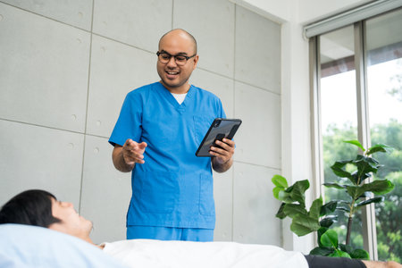 Physical therapy. Male Nurse aids young man in recovering from spine injury and providing massage. Healthcare and with person for physical therapy rehabilitationの写真素材