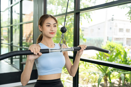 Young woman wearing sportswear warming up in fitness gym before exercise. Woman stretching before...