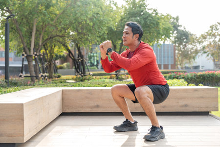 Senior old asian man wearing sportswear warming up before running outdoor. Portraits of mature man stretching body before running at public park. Training athlete work out at outdoor natureの写真素材