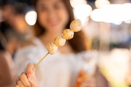 Asian woman enjoy eating noodles street food at night market. Happy tourists Beautiful female with Traditional thailand bangkok food.の写真素材