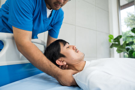 Physical therapy. Male Nurse aids young man in recovering from spine injury and providing orthopedic massage Orthopedic healthcare and chiropractor with person for physical therapy rehabilitationの写真素材