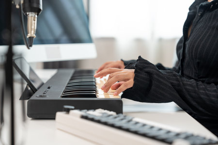 Professional Musician with condenser microphone and tablet for Mixing Mastering music. Music composer woman composing a song with guitar and piano keyboard at digital Recording home studioの写真素材