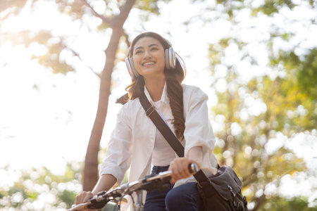 Young Asian woman riding bike in nature public park. Sustainable save energy lifestyle. Commute and carbon neutral transportation. Asian woman cycling bike on the nature road.の写真素材