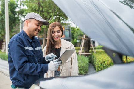 Young female driver call Auto mechanic car service. Broken Down car outside the road help and support customer. Discussing repairs problems to vehicle.の写真素材