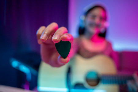 Professional Musician with condenser microphone and tablet for Mixing Mastering music. Music composer woman composing a song with guitar and piano keyboard at digital Recording home studio neon lightの写真素材