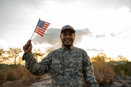 Hand Waving the Flag of the United States of America in memorial day . Us soldier holding American...