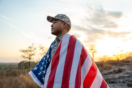 Hand Waving the Flag of the United States of America in memorial day . Us soldier holding American flag celebrating.US Army soldier celebrates holding USA flag celebrating Independence USA dayの写真素材