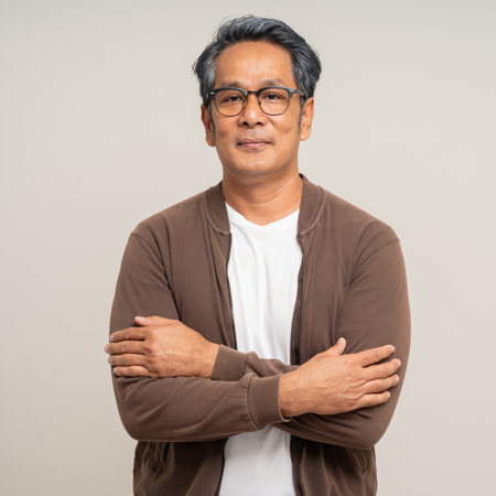 Handsome asian mature old man standing on isolated white background. Happy Portrait of cheerful smiling senior asian man looking at camera. Mature People and lifestyleの写真素材