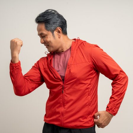 Senior asian old man with sportswear on isolated white background. Portrait happy healthy fit and firm attractive sporty mature man standing pose exercise workout in studio.の写真素材