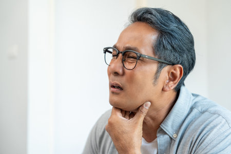 Old man senior have throat irritation mucus and coughing. Fever headache respiratory tract infection. Mature man unhealthy Sickness need to consult a doctor and get treatment.の写真素材