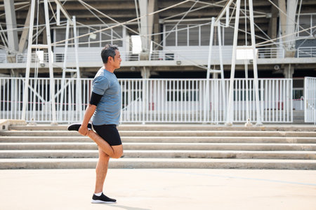 Senior old asian man wearing sportswear warming up before running outdoor. Portraits of Mature man...
