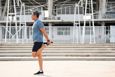 Senior old asian man wearing sportswear warming up before running outdoor. Portraits of Mature man...