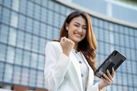 Portrait beautiful Businesswoman in suit with tablet standing at the buildings downtown. Confident woman using tablet. Executive Smart businessmanの写真素材
