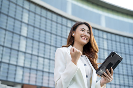 Portrait beautiful Businesswoman in suit with tablet standing at the buildings downtown. Confident woman using tablet. Executive Smart businessmanの写真素材