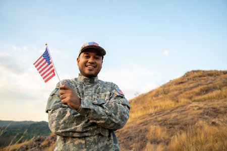 Hand Waving the Flag of the United States of America in memorial day . Us soldier holding American flag celebrating.US Army soldier celebrates holding USA flag celebrating Independence USA dayの写真素材