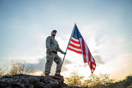 Hand Waving the Flag of the United States of America in memorial day . Us soldier holding American flag celebrating.US Army soldier celebrates holding USA flag celebrating Independence USA dayの写真素材