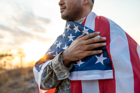 Hand Waving the Flag of the United States of America in memorial day . Us soldier holding American flag celebrating.US Army soldier celebrates holding USA flag celebrating Independence USA dayの写真素材