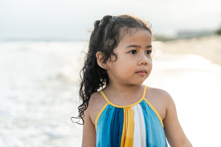 Cheerful adorable little girl having fun outdoor and playing with sand with beach kid toys on the...