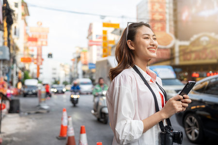 Asian woman enjoy eating street food at night market. Traveler Asian blogger women Happy tourists Beautiful female with Traditional food local road at thailand bangkok city.の写真素材