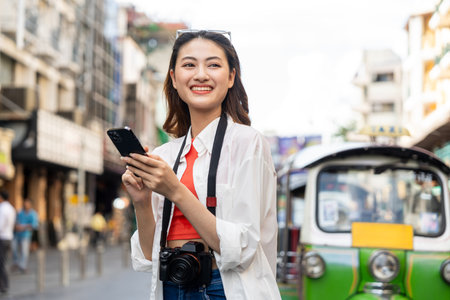 Young Asian woman traveling backpacker in Khaosan Road outdoor market in Bangkok Thailand. Happy female tourist walking in the downtown street traditional marketの写真素材