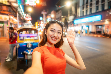 Asian woman enjoy eating street food at night market. Traveler Asian blogger women Happy tourists Beautiful female with Traditional food local road at thailand bangkok city.の写真素材