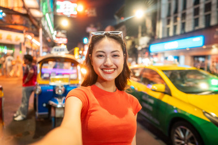 Asian woman enjoy eating street food at night market. Traveler Asian blogger women Happy tourists Beautiful female with Traditional food local road at thailand bangkok city.の写真素材