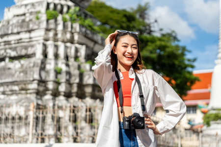 Young Asian woman traveling backpacker walking in temple at Bangkok Thailand. Happy female tourist...