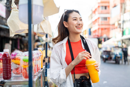 Young Asian woman traveling backpacker in Khaosan Road outdoor market in Bangkok Thailand. Happy female tourist walking in the downtown street traditional marketの写真素材