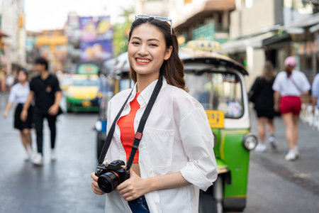 Young Asian woman traveling backpacker in Khaosan Road outdoor market in Bangkok Thailand. Happy...