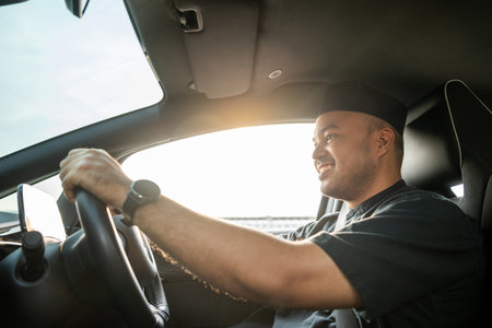 Asian muslim business man getting new car. Happy and excited. Smiling man islamic driving vehicle on the road wearing songkok cap. Businessman buying driving new car
